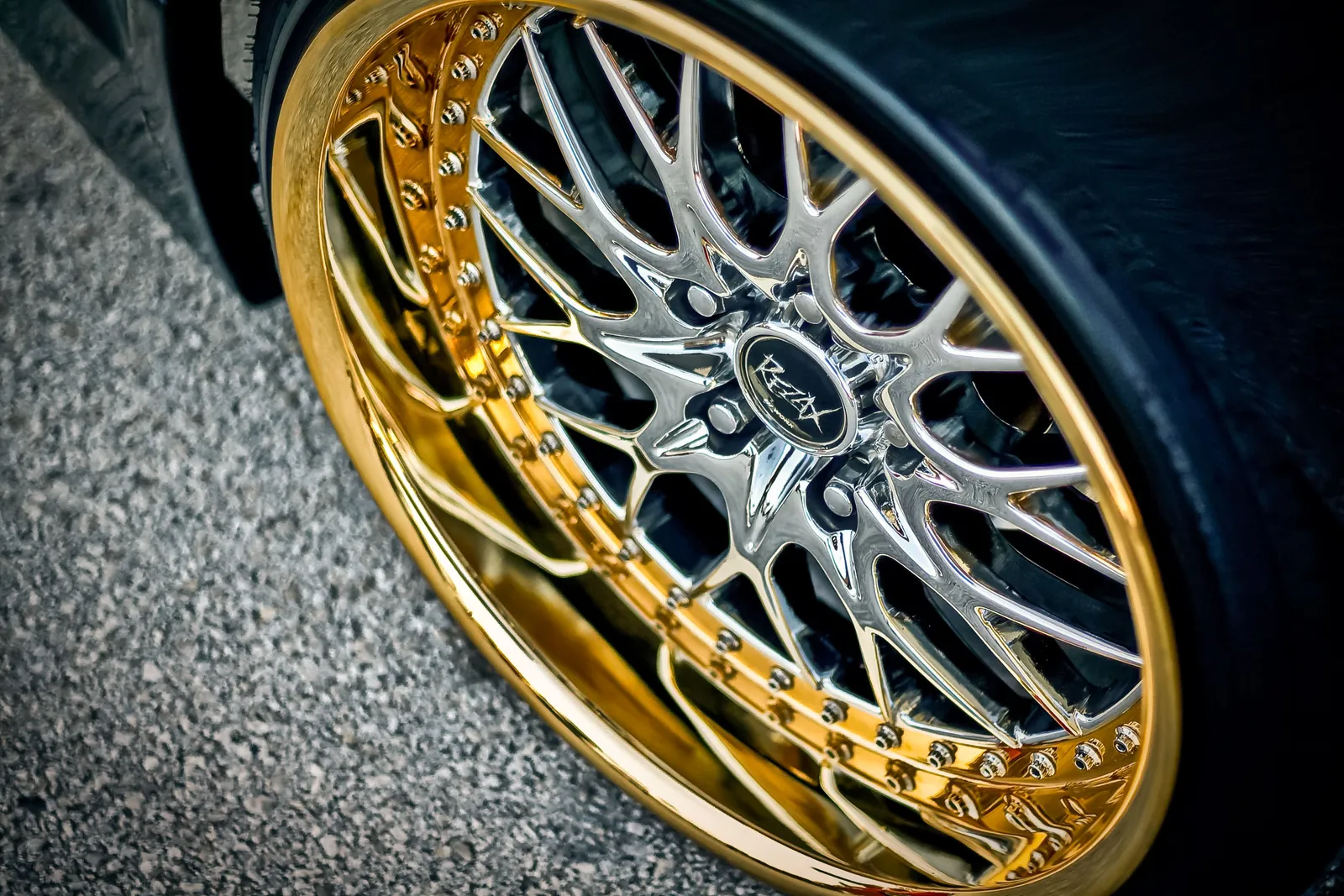 Jante de liga leve cromada com aro dourado montada num automóvel.